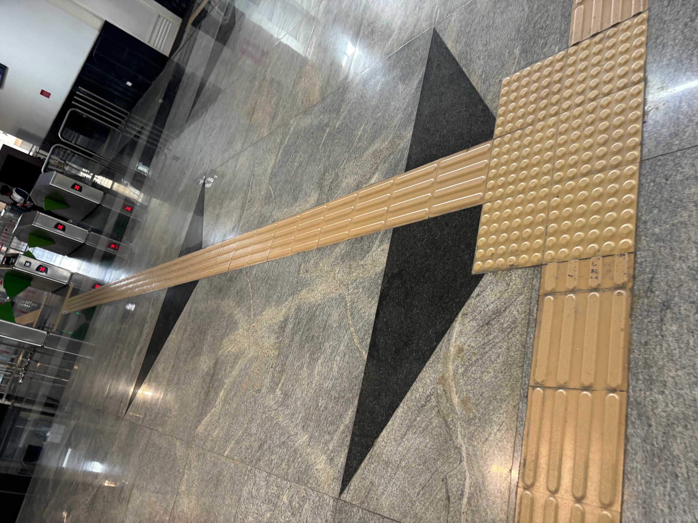 Granite flooring with a black inlay and yellow tactile paving.