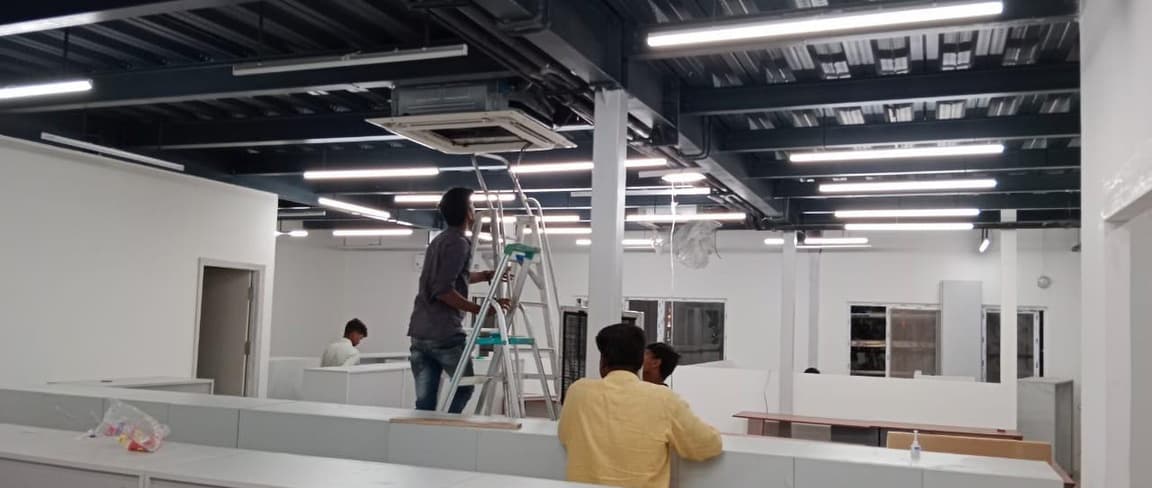 Fit-out team working at height on the ceiling and services.