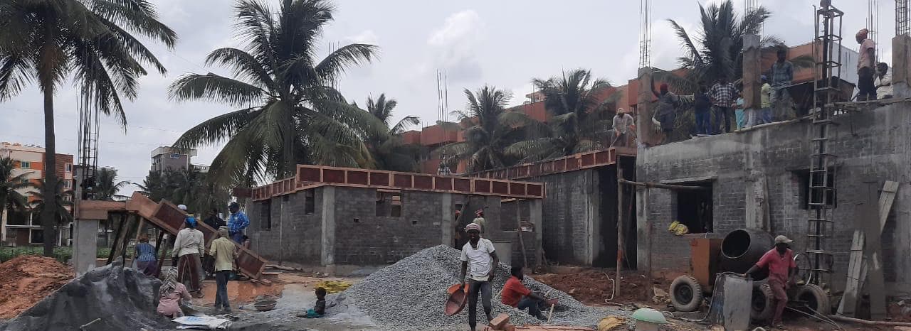 Villas rising on site, with aggregate and materials stacked in front.