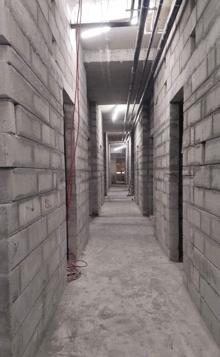 Long corridor with fresh block walls on both sides.