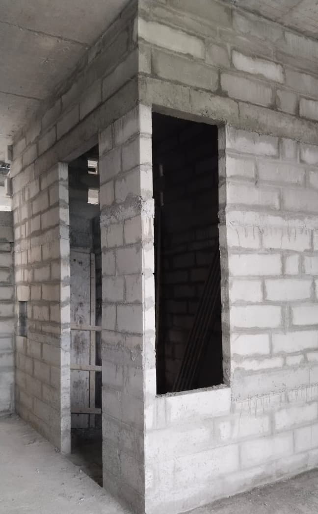 Block wall with a door opening and a window opening.