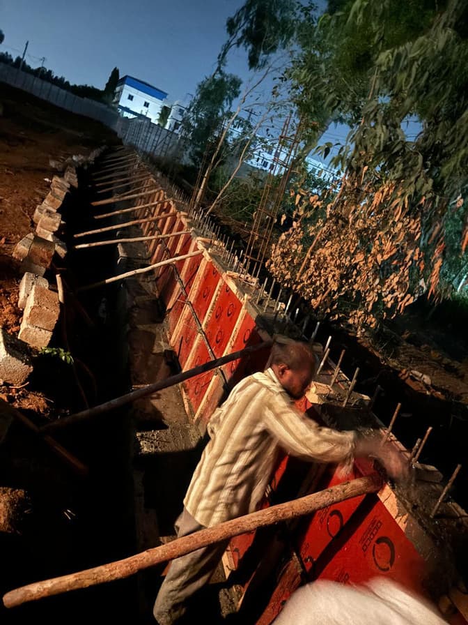 Worker fixing formwork and reinforcement for the wall.
