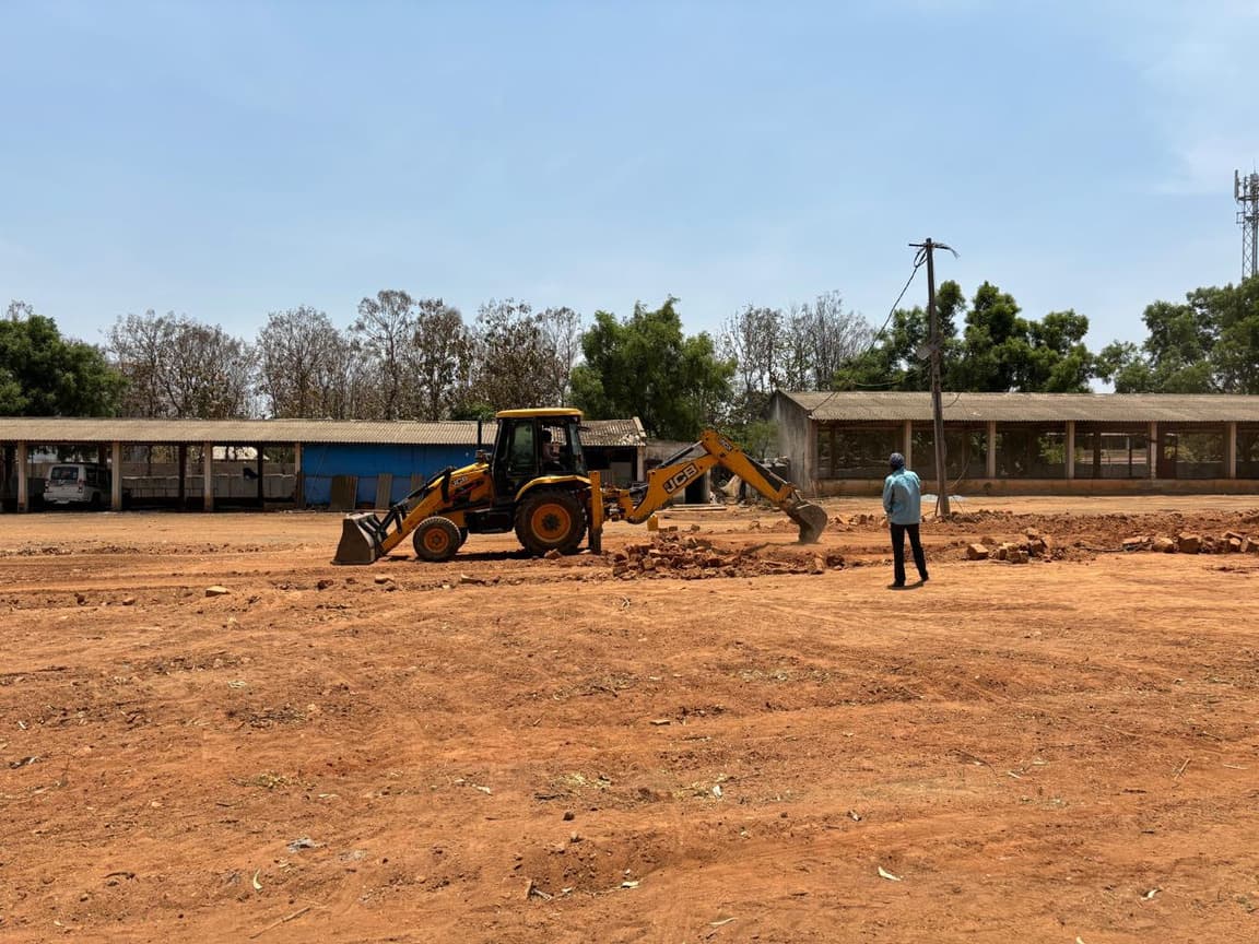 Excavator grading open land for the layout.