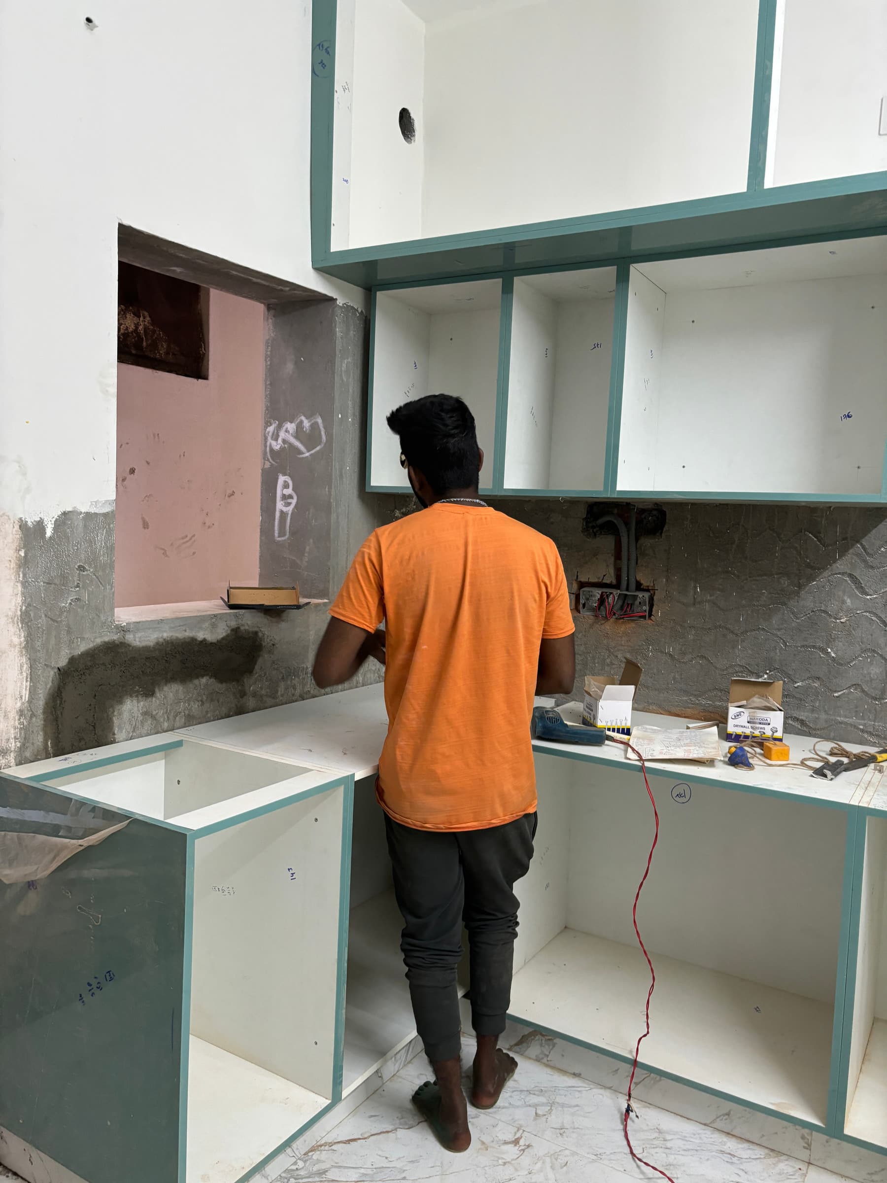 Worker installing modular kitchen units during a home renovation.