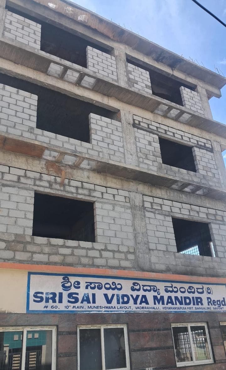 Block-walled upper floors above the Sri Sai Vidya Mandir signboard.
