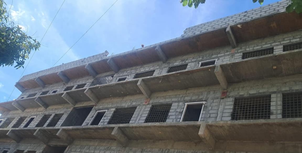 Street view of the school building's block-masonry elevation.