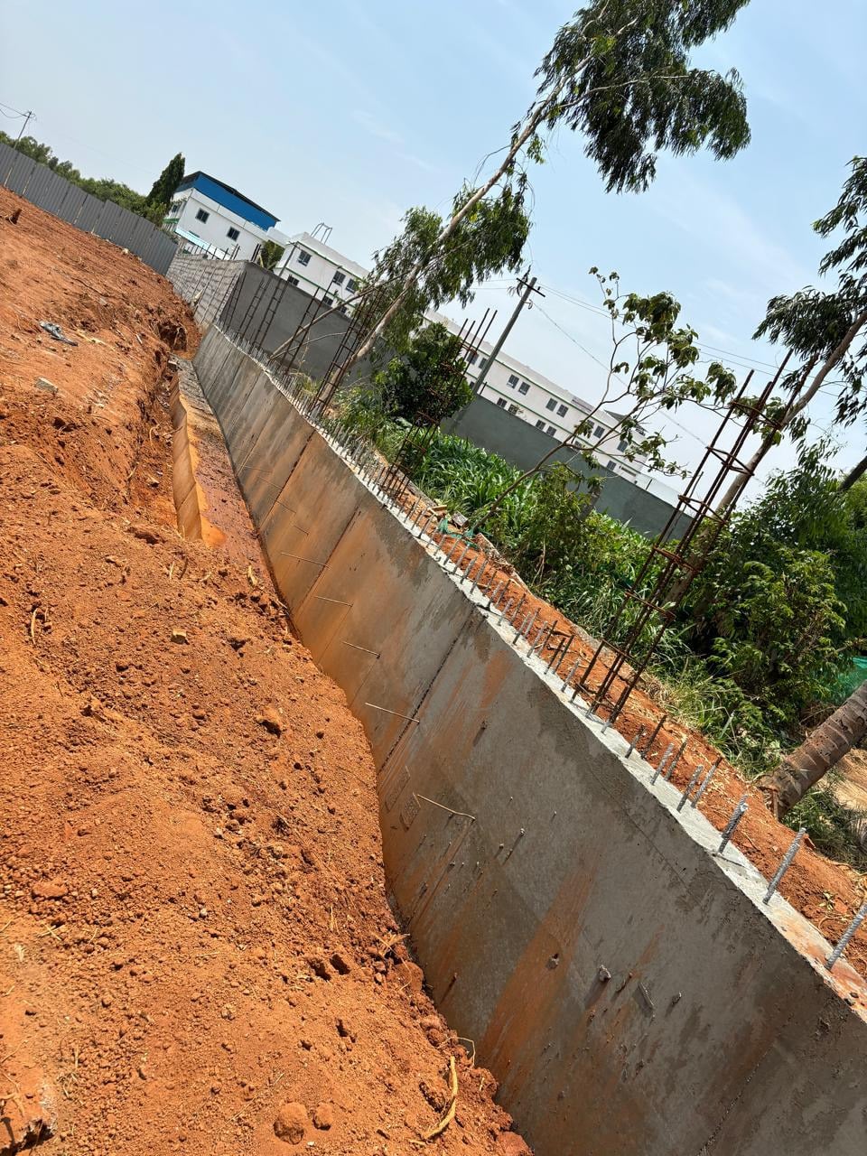 Retaining wall running straight beside a boundary wall.
