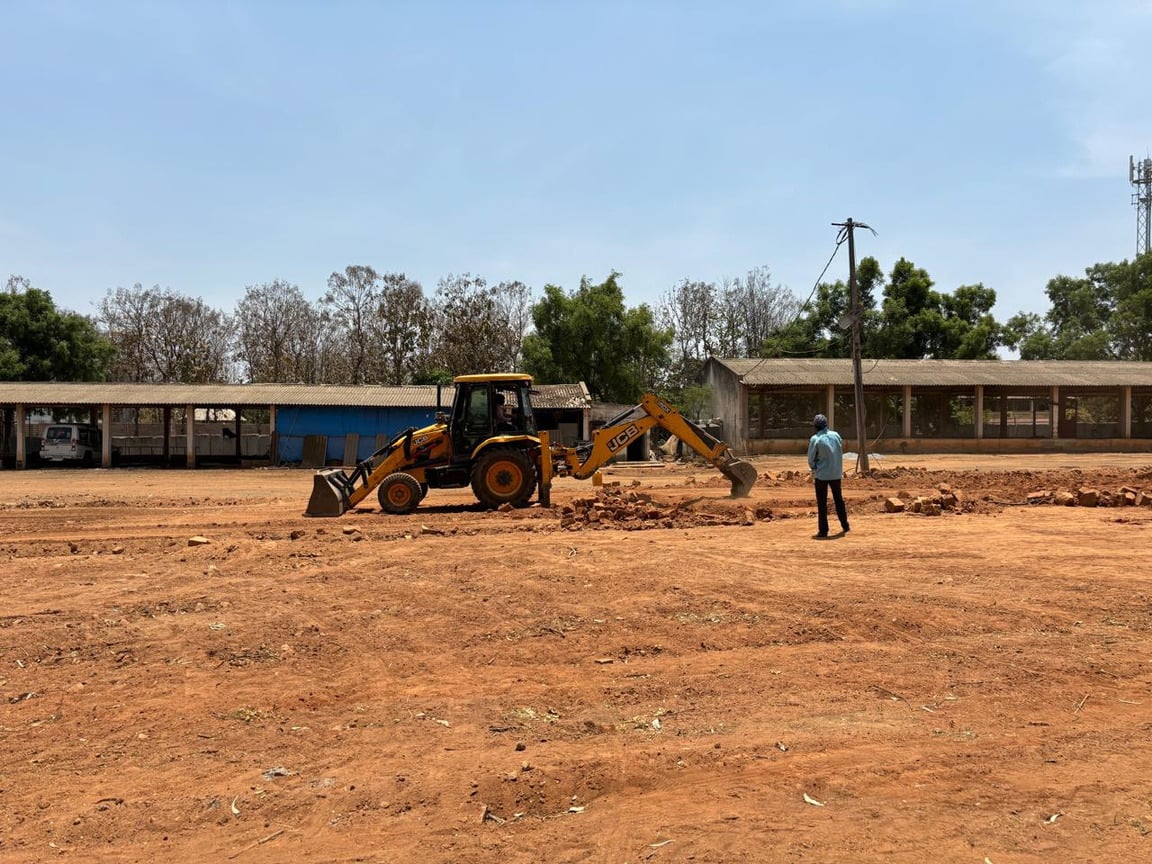 Excavator grading open land for the layout.