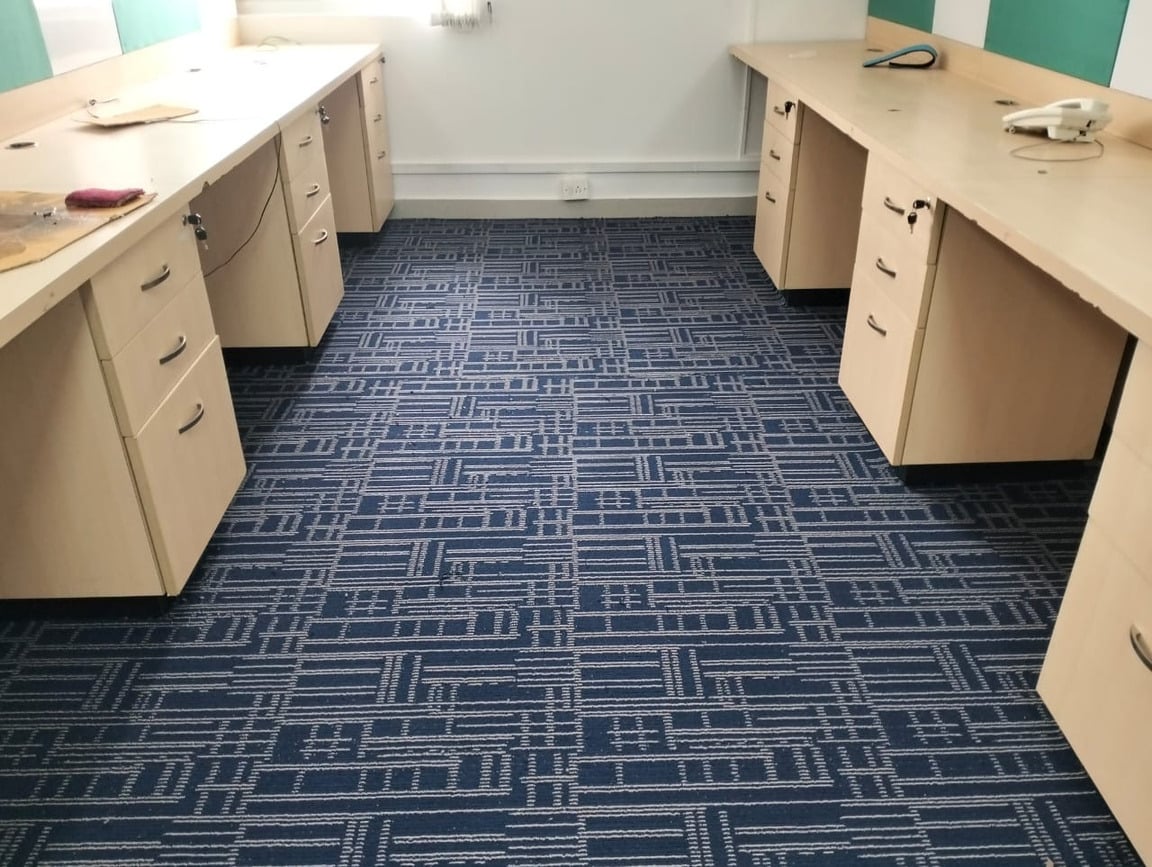 Carpeted work area with desks and pedestal drawers.